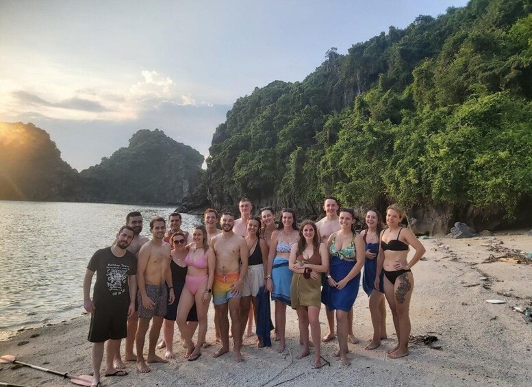 A group of people on a beach with a forested hill in the background. 4