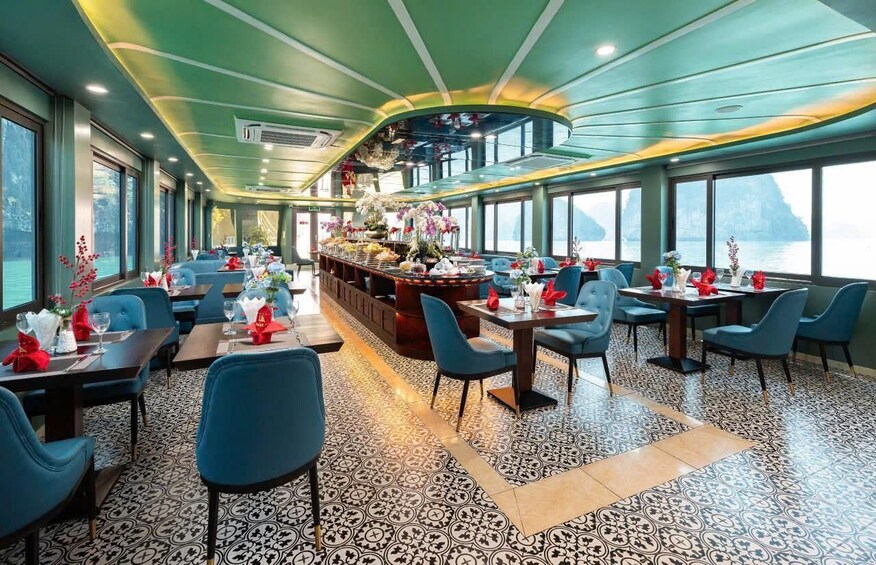 A restaurant with blue chairs, a patterned floor, and a view of the water. 5