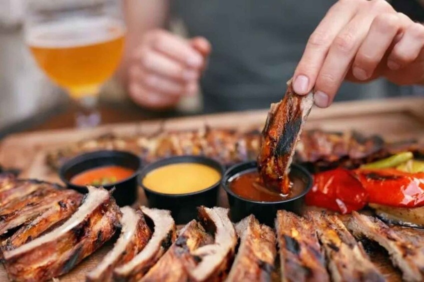 Grilled meat slices with dipping sauces and a glass of beer. 4