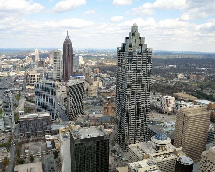 A cityscape with multiple high-rise buildings, including a distinctive triangular skyscraper and a cylindrical building with a dome. 1