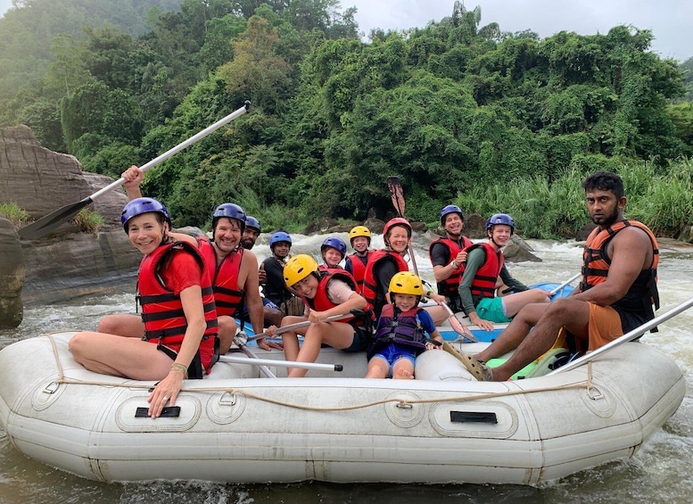 A group of people in a white inflatable raft on a river surrounded by dense greenery. 4