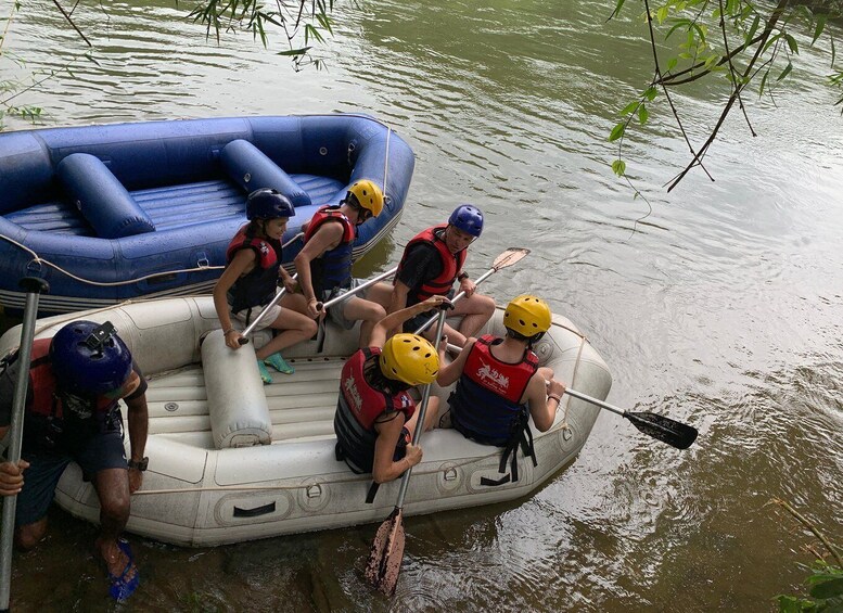 People in inflatable boats on a river, wearing life jackets and helmets. 3