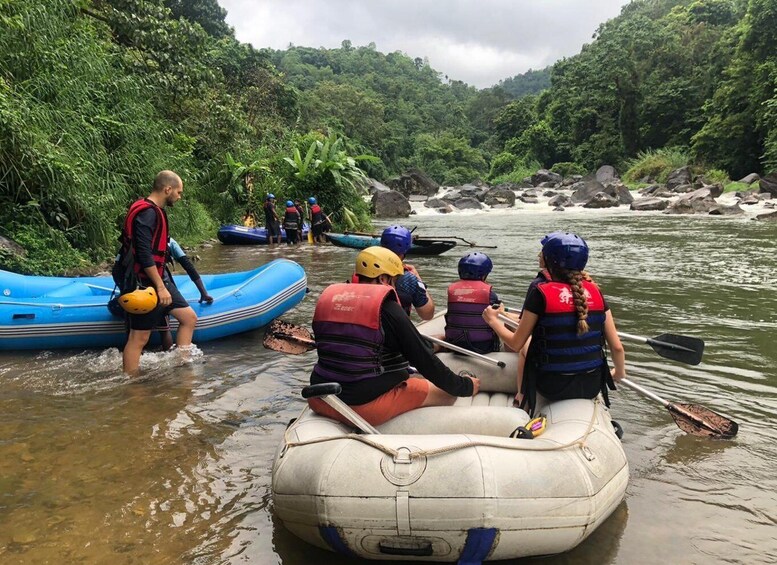 People in inflatable rafts on a river surrounded by dense greenery. 5