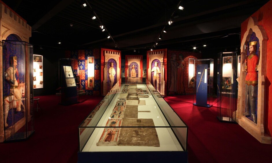An indoor museum with medieval artifacts and illuminated manuscripts on display. 5