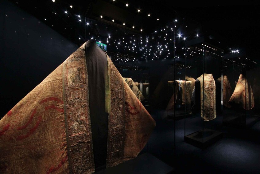 Ancient textiles displayed in a museum with star-shaped ceiling lights. 2