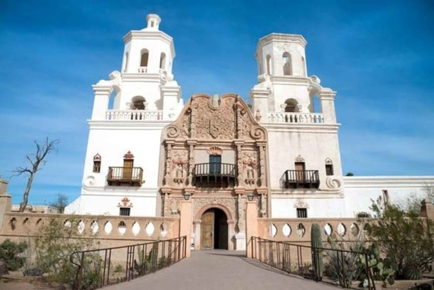 A historic white building with two bell towers and a central entrance with intricate carvings. 3