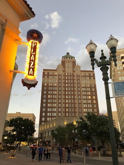 A city street with a prominent building labeled 'PLAZA' and a theater sign. 5