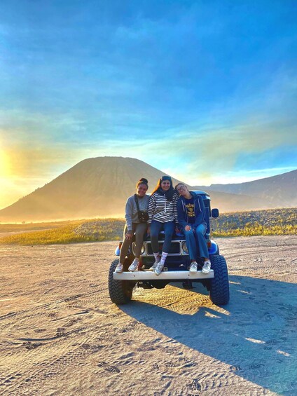 Three people on a Segway in a desert landscape with mountains in the background. 2