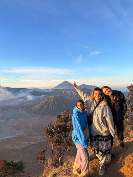 A group of people on a mountain with a volcano in the background. 1