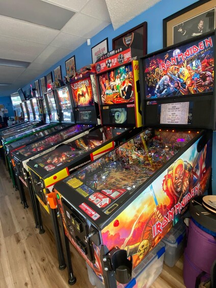 A row of pinball machines with vibrant artwork and various game titles. 3