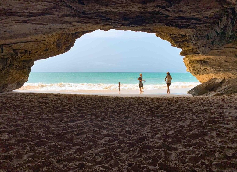 A beach with a natural rock archway. 4
