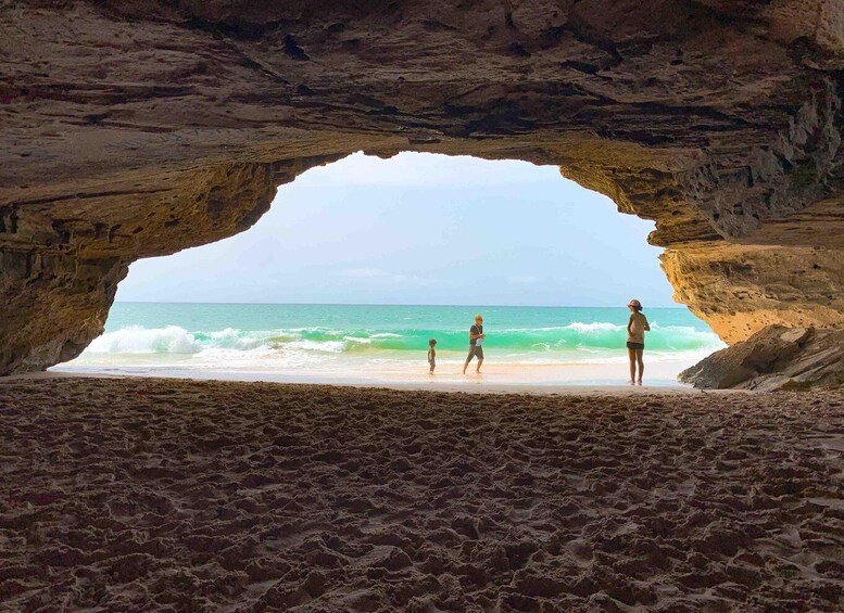 A beach with a natural rock arch formation. 2