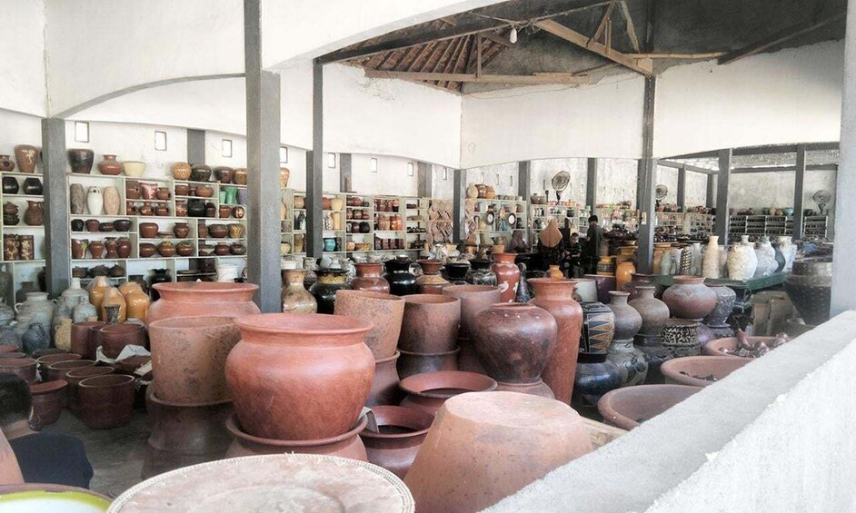 A pottery shop with various ceramic items on shelves and tables. 3