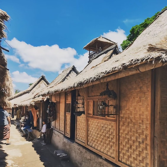 A traditional village with thatched-roof houses and woven wooden walls. 5
