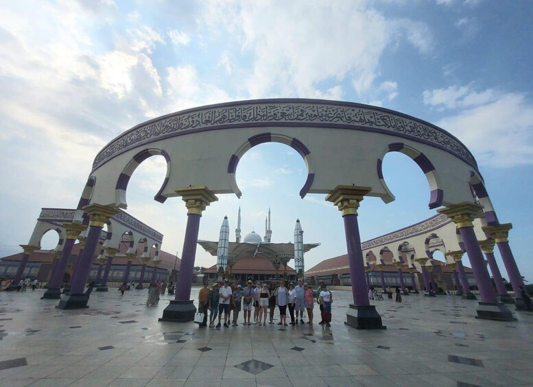 A mosque with a large archway and minarets in the background. 5