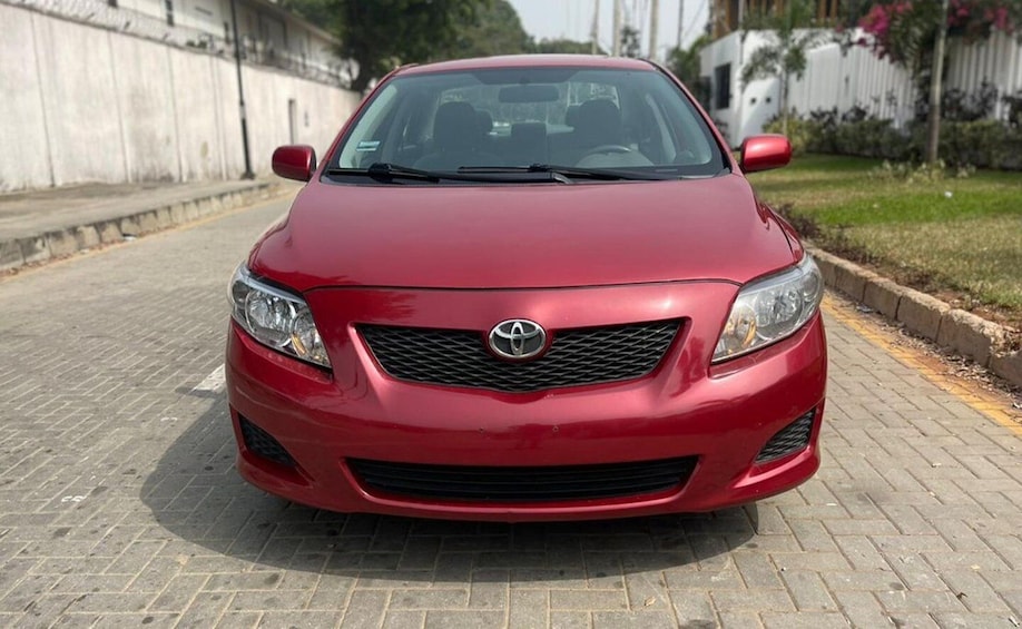 A red car parked on a paved road. 2