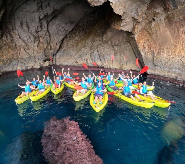 A group of people kayaking in a cave with clear water. 3