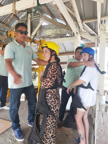 A group of people in a covered outdoor area with metal roofing and wooden beams. 5