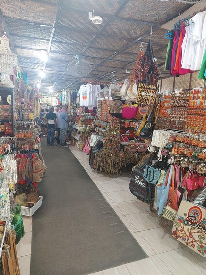 A market with various stalls selling clothes, bags, and accessories. 3