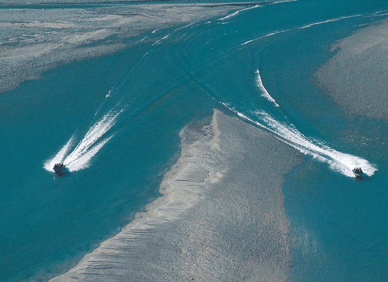 A large body of water with two boats creating wake patterns. 2