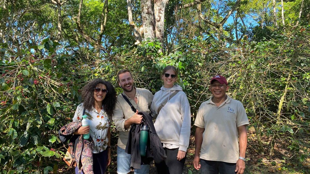 A group of people standing in a forested area with dense foliage and trees. 2