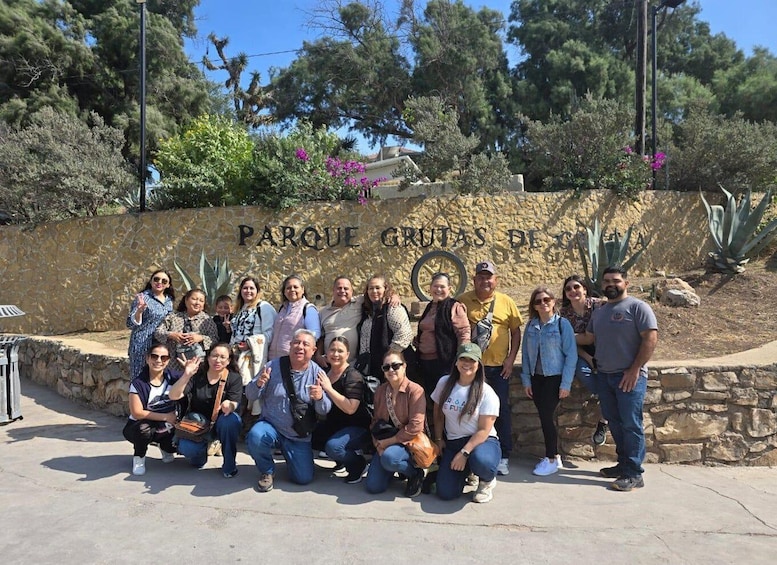 A group of people posing in front of a stone wall with the inscription 'PARQUE CRUZAS DE'. 4