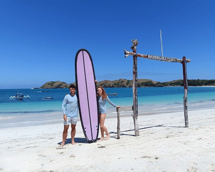 A beach with a wooden signpost and a surfboard. 4