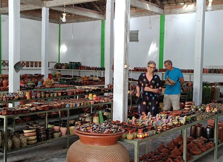 A pottery market with various ceramic items displayed on shelves and tables. 5