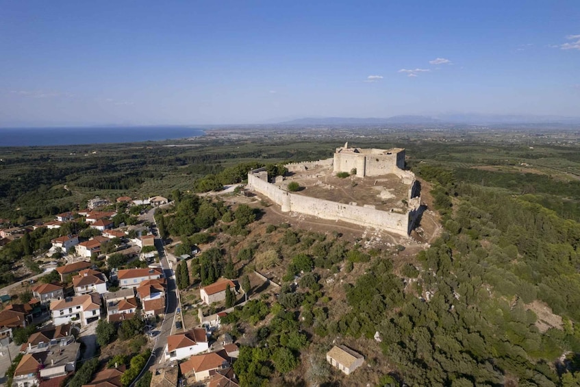 A coastal town with a historic fortification on a hill overlooking the sea. 3