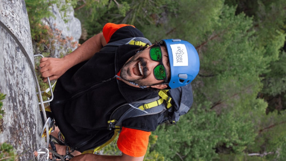 A person climbing a rock face with a helmet and harness. 5