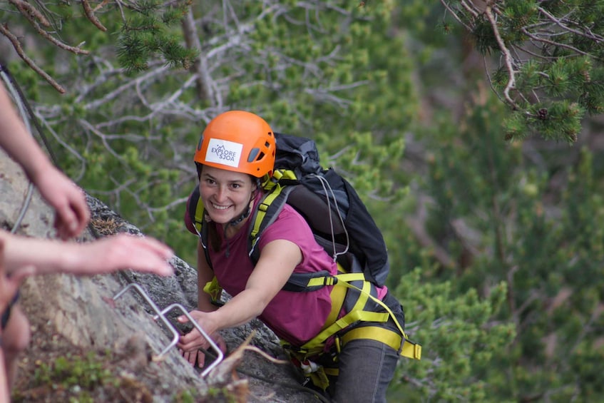 A person climbing a rocky mountain with a helmet and harness. 3