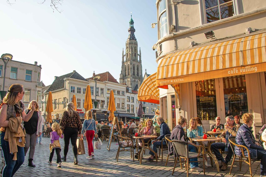 A bustling outdoor café with people sitting and walking around. 4