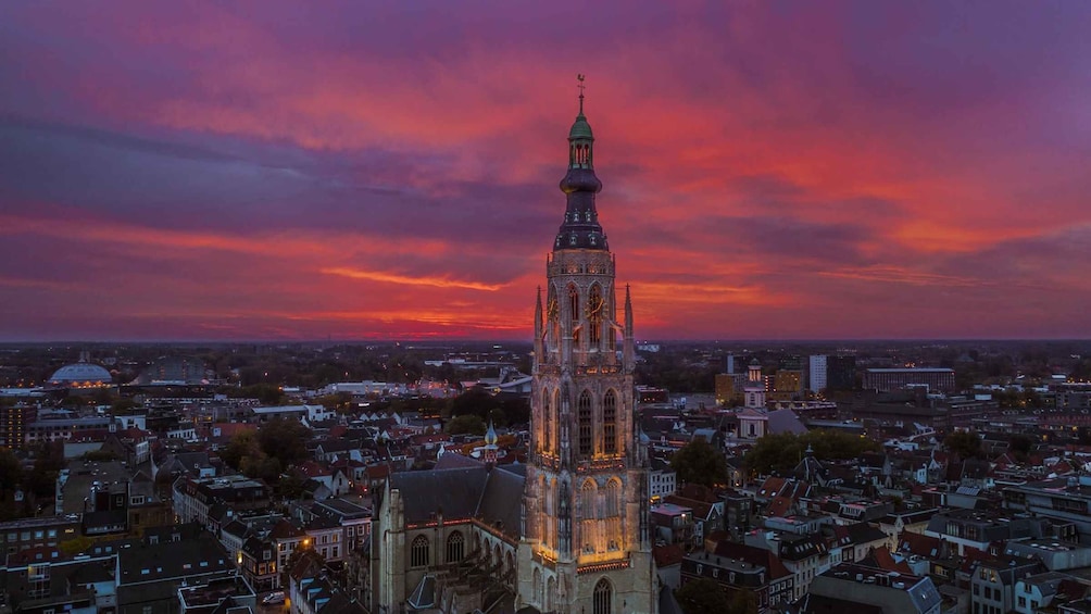 A cityscape with a prominent church tower against a sunset sky. 3