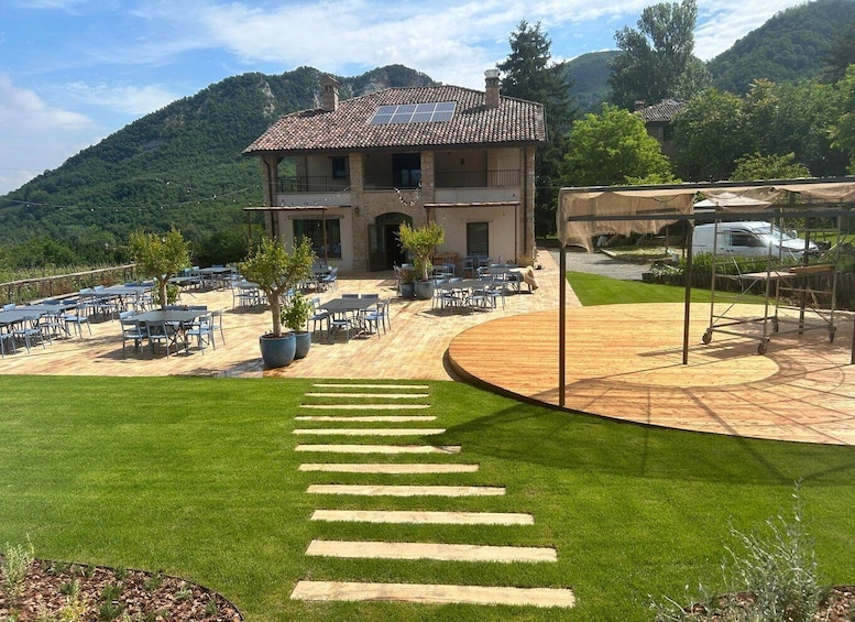 A building with a tiled roof, outdoor seating, and a paved walkway leading to it. 1