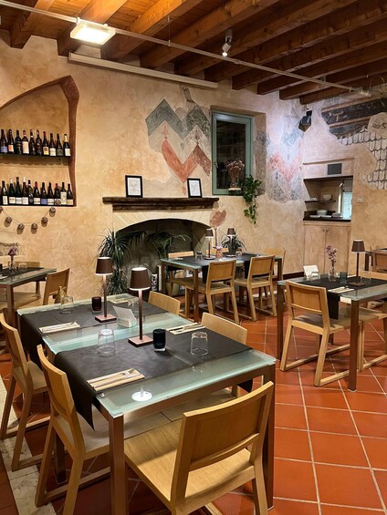 A restaurant interior with wooden tables, chairs, a fireplace, and a wall mural. 3