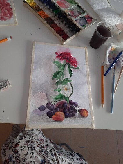 A watercolor painting of a red flower with green leaves and grapes on a white background. 3