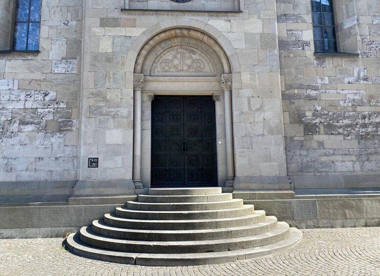A stone building with a large arched entrance and a set of stone steps leading up to it. 4