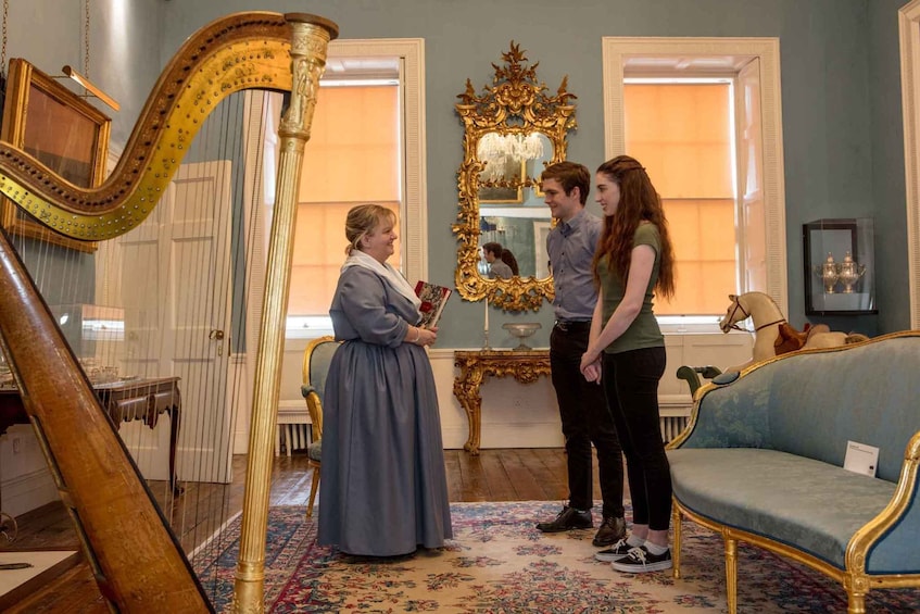A room with a harp, a mirror, a sofa, and a horse statue. 2