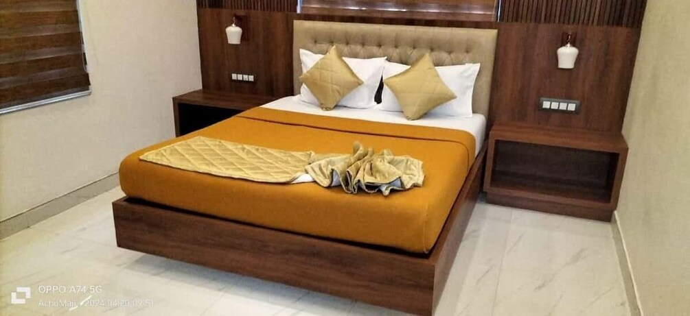 A bedroom with a bed, wooden headboard, and nightstands. 4