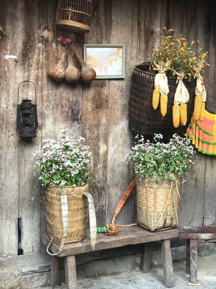 A rustic wooden wall with various decorations including baskets, a lantern, and corn on the cob. 4
