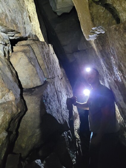 A person in a cave with a flashlight. 4