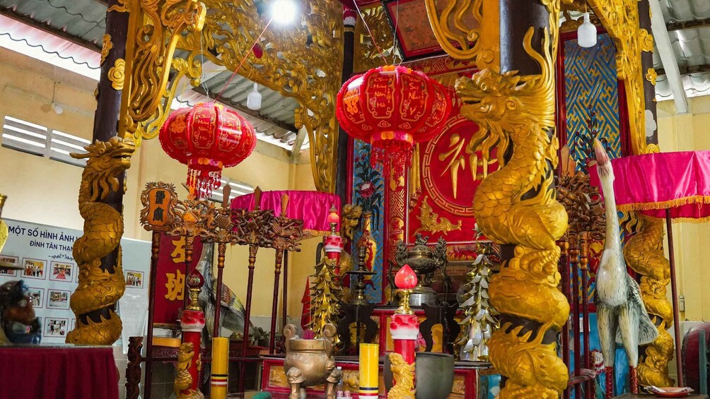 A temple interior with golden statues, red lanterns, and traditional decorations. 4