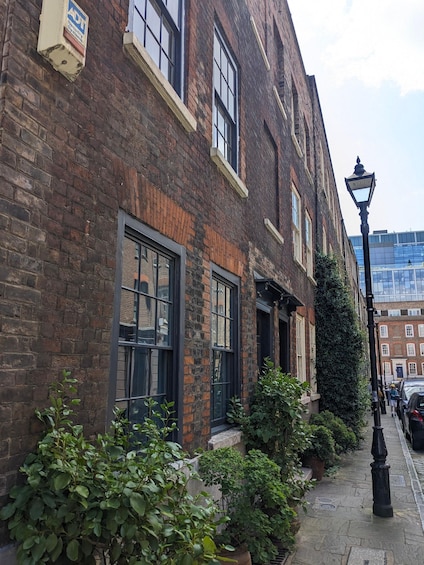 A brick building with large windows and a black lamppost. 1