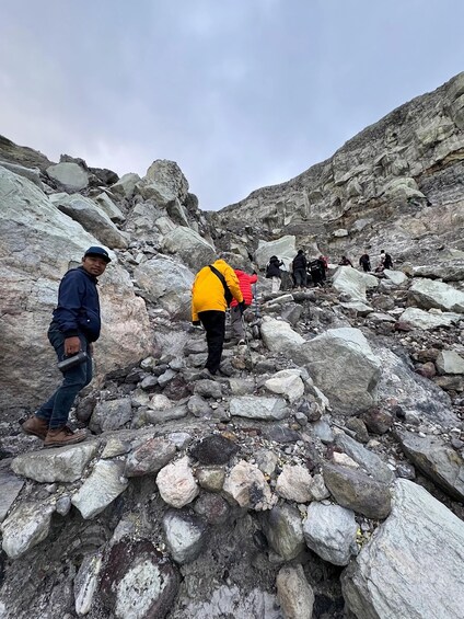 A group of hikers navigating a rocky mountainous terrain. 1