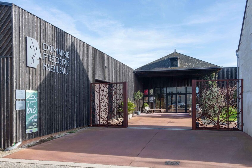 A building entrance with a wooden facade and a sign reading 'DOMAINE FREDERIC MABLEAU.' 3