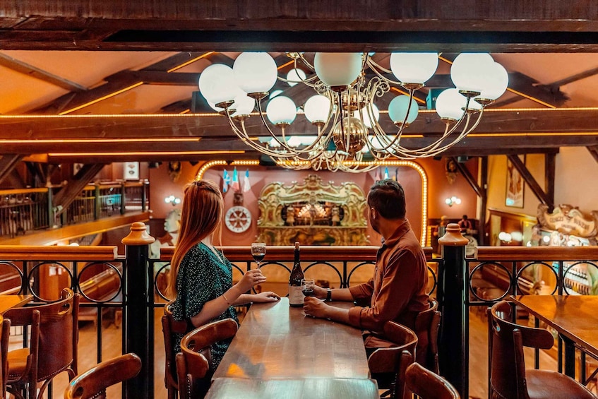 A couple seated at a bar with a chandelier overhead. 4