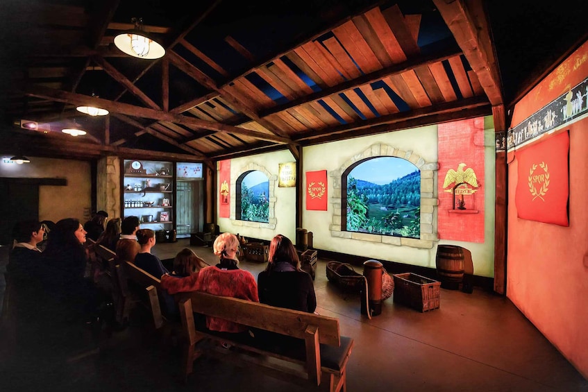 A rustic interior with wooden beams, a large arched window, and a red banner with a logo. 1