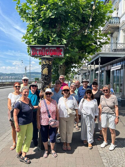 A group of people standing in front of a sign that reads 'Welcome to the town.' 2