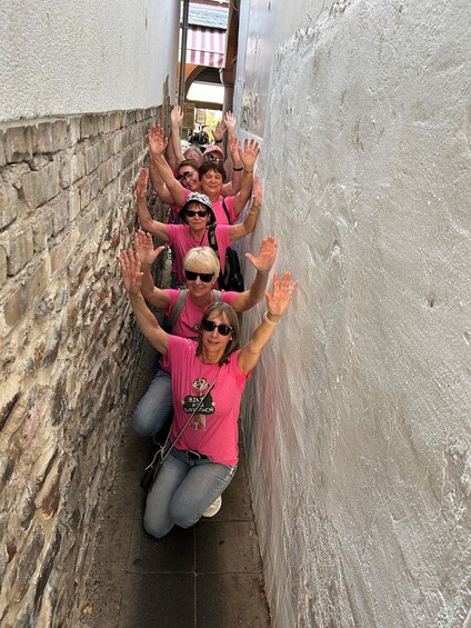 A group of people in a narrow alleyway with brick walls and a metal door. 5