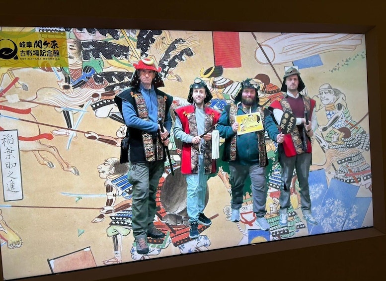 A group of people in traditional costumes standing in front of a mural. 1